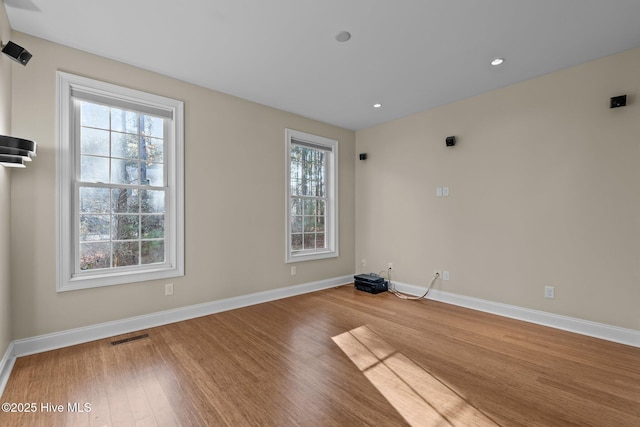 unfurnished room featuring hardwood / wood-style floors and a wealth of natural light