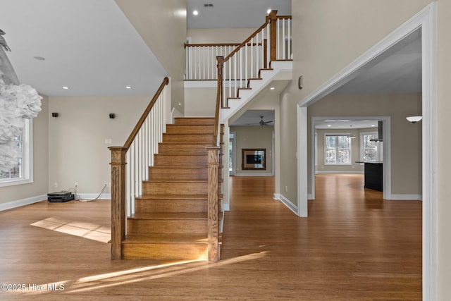 staircase with hardwood / wood-style flooring and ceiling fan