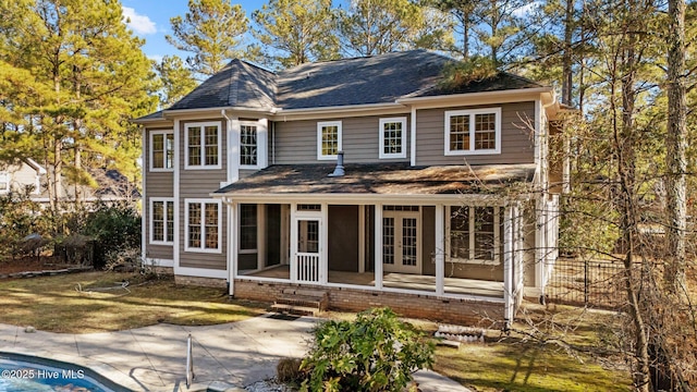 back of property with a sunroom and french doors