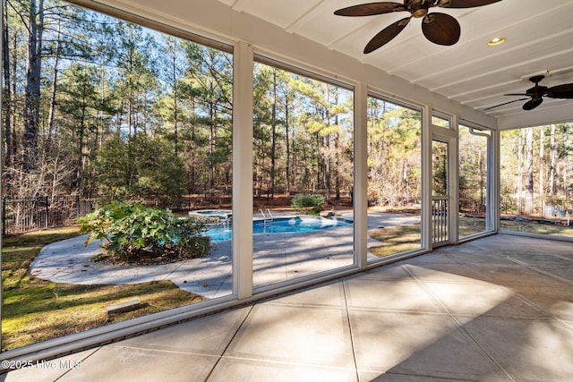 unfurnished sunroom featuring ceiling fan