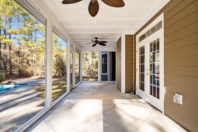 unfurnished sunroom featuring ceiling fan and french doors