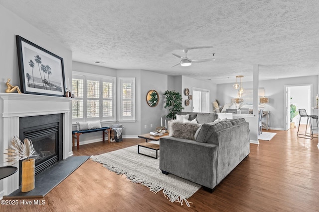 living room featuring a textured ceiling, dark hardwood / wood-style floors, and ceiling fan