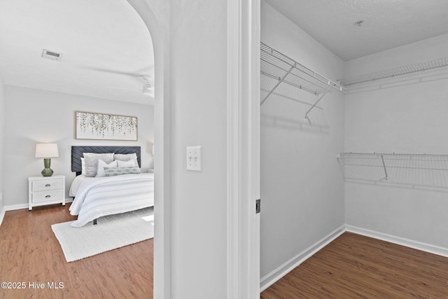 walk in closet featuring wood-type flooring and ceiling fan