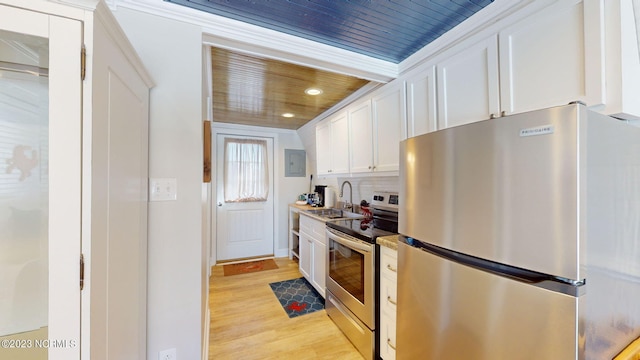 kitchen with decorative backsplash, light hardwood / wood-style floors, white cabinetry, and appliances with stainless steel finishes