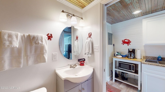 bathroom featuring hardwood / wood-style floors, vanity, wooden ceiling, and crown molding