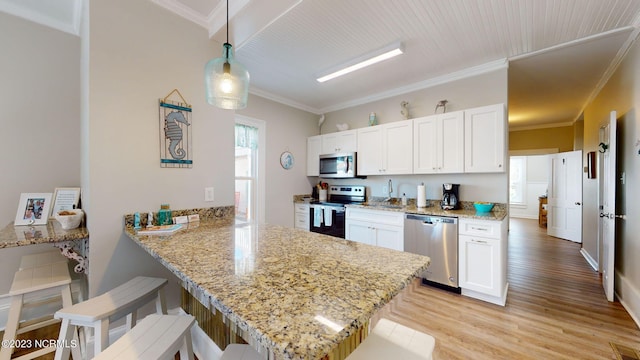 kitchen with white cabinetry, kitchen peninsula, hanging light fixtures, and appliances with stainless steel finishes