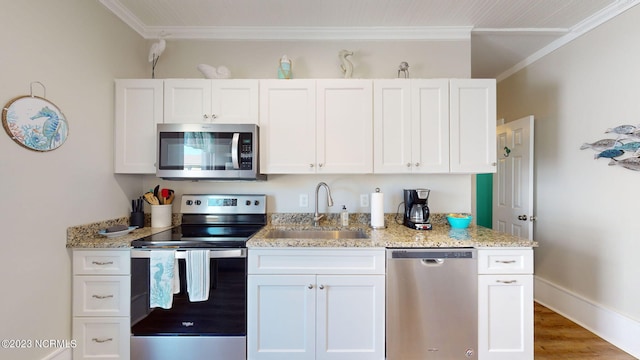 kitchen with white cabinetry, sink, stainless steel appliances, and ornamental molding