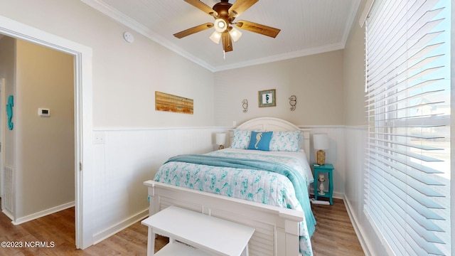 bedroom featuring ceiling fan, wood-type flooring, and ornamental molding