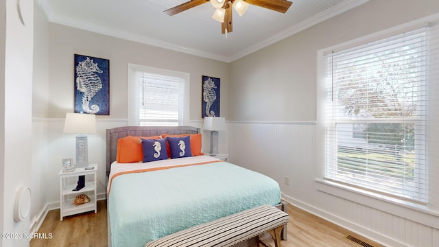 bedroom with hardwood / wood-style flooring, ceiling fan, and crown molding