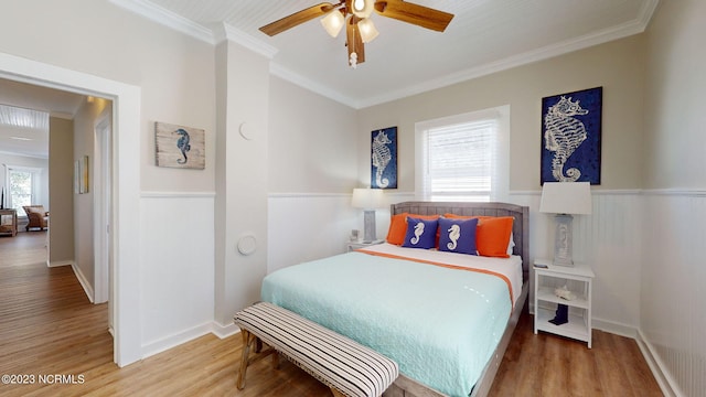 bedroom with crown molding, ceiling fan, and wood-type flooring