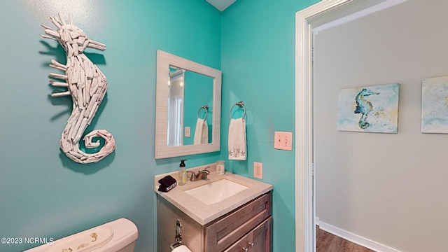 bathroom with vanity, hardwood / wood-style flooring, and toilet