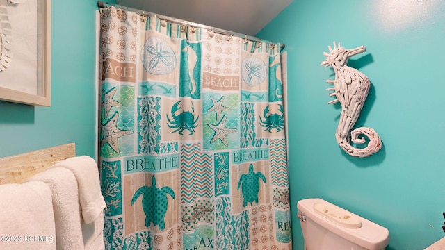 bathroom with curtained shower and toilet