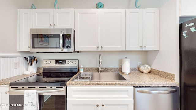 kitchen featuring white cabinets, appliances with stainless steel finishes, and sink