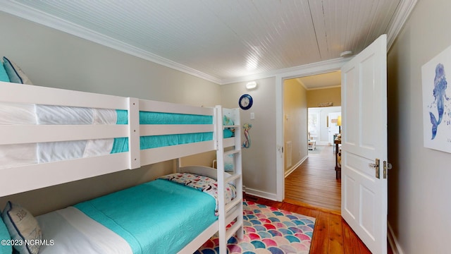 bedroom with dark wood-type flooring and crown molding