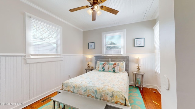 bedroom with ceiling fan, hardwood / wood-style floors, and crown molding