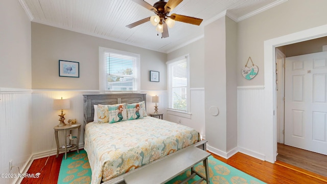 bedroom with hardwood / wood-style floors, ceiling fan, and crown molding