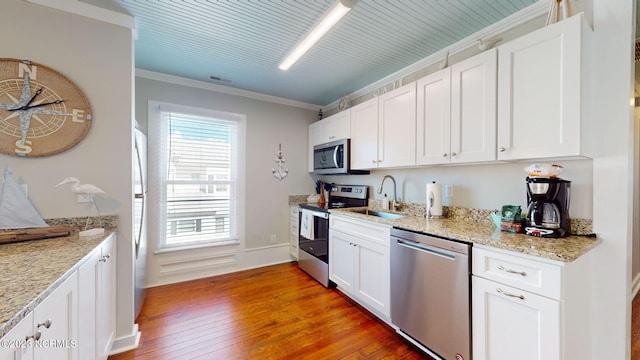 kitchen featuring white cabinetry, sink, dark wood-type flooring, appliances with stainless steel finishes, and ornamental molding