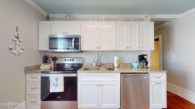 kitchen featuring sink, light stone countertops, ornamental molding, white cabinetry, and stainless steel appliances