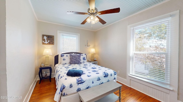 bedroom with hardwood / wood-style floors, ceiling fan, and ornamental molding