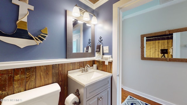 bathroom with vanity, toilet, and crown molding