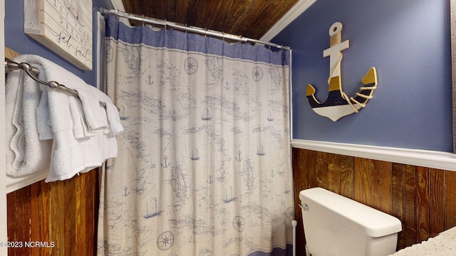 bathroom featuring ornamental molding, wood walls, toilet, wood ceiling, and a shower with shower curtain