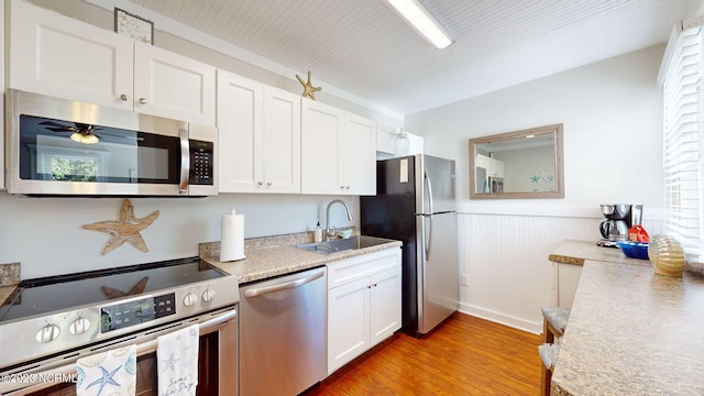 kitchen featuring white cabinetry, sink, light wood-type flooring, and appliances with stainless steel finishes