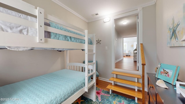 bedroom with hardwood / wood-style floors and ornamental molding