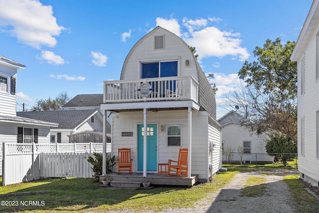 view of front facade with a balcony and a front yard