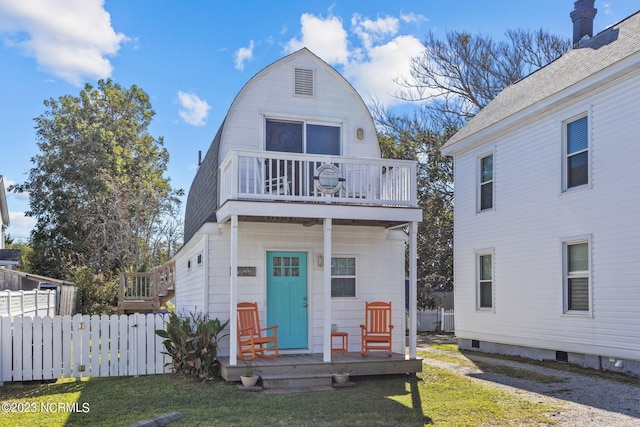 view of front of house with a balcony and a front yard