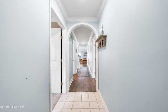 hallway with light tile patterned flooring and crown molding