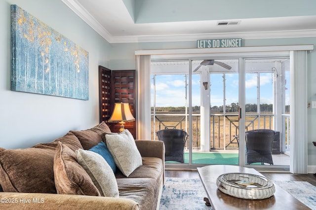 living room featuring wood-type flooring, ceiling fan, and crown molding