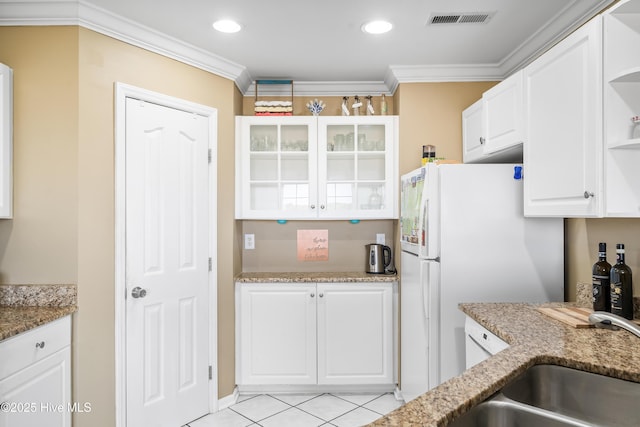 kitchen featuring white cabinetry, crown molding, light tile patterned floors, and light stone countertops