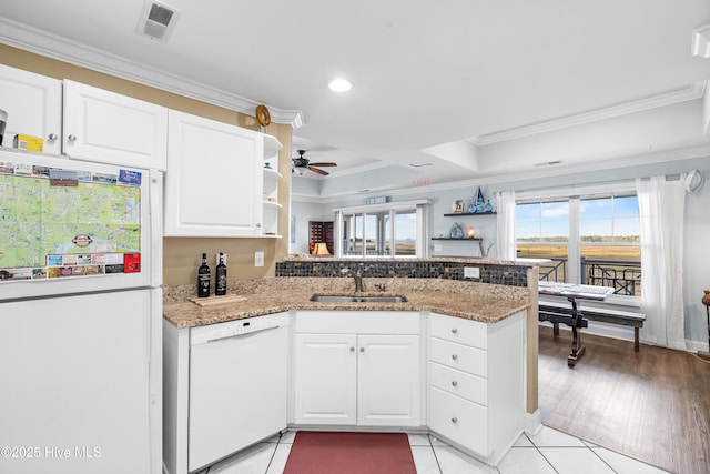 kitchen with kitchen peninsula, white appliances, sink, stone counters, and white cabinetry