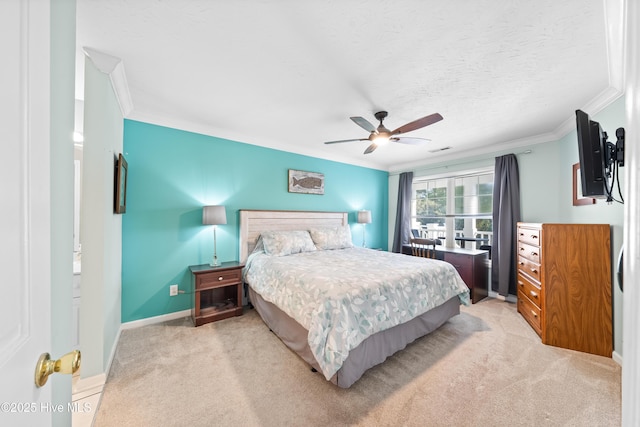 bedroom with ceiling fan, crown molding, light carpet, and a textured ceiling