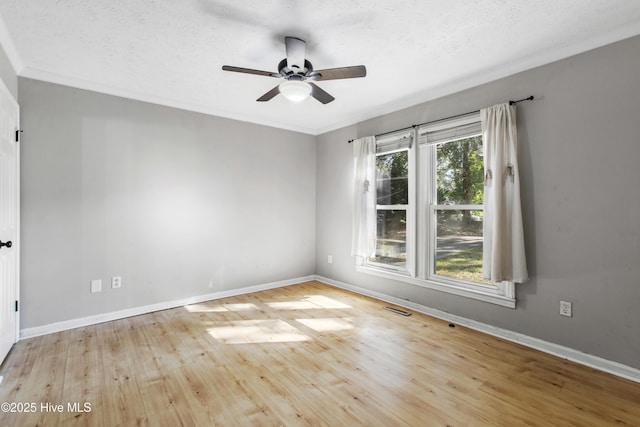 empty room with ceiling fan, crown molding, a textured ceiling, and light wood-type flooring