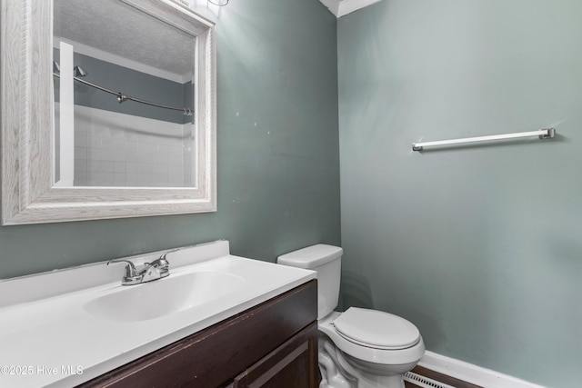 bathroom with a shower, vanity, ornamental molding, and toilet