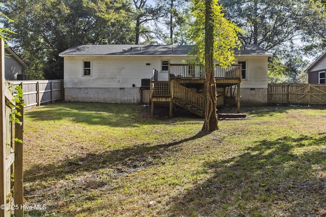 rear view of property with a yard and a wooden deck