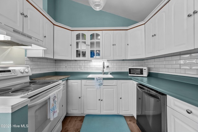 kitchen with decorative backsplash, white appliances, white cabinetry, and sink