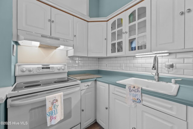 kitchen with electric range, white cabinets, sink, and tasteful backsplash