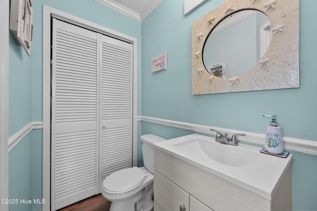 bathroom featuring wood-type flooring, vanity, toilet, and ornamental molding