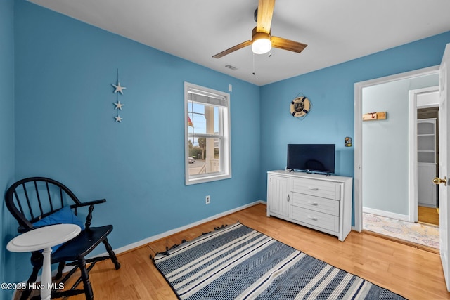 sitting room with light hardwood / wood-style floors and ceiling fan