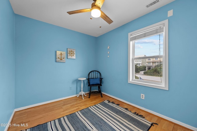 living area with ceiling fan and wood-type flooring