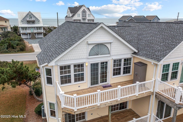 rear view of property featuring a deck with water view