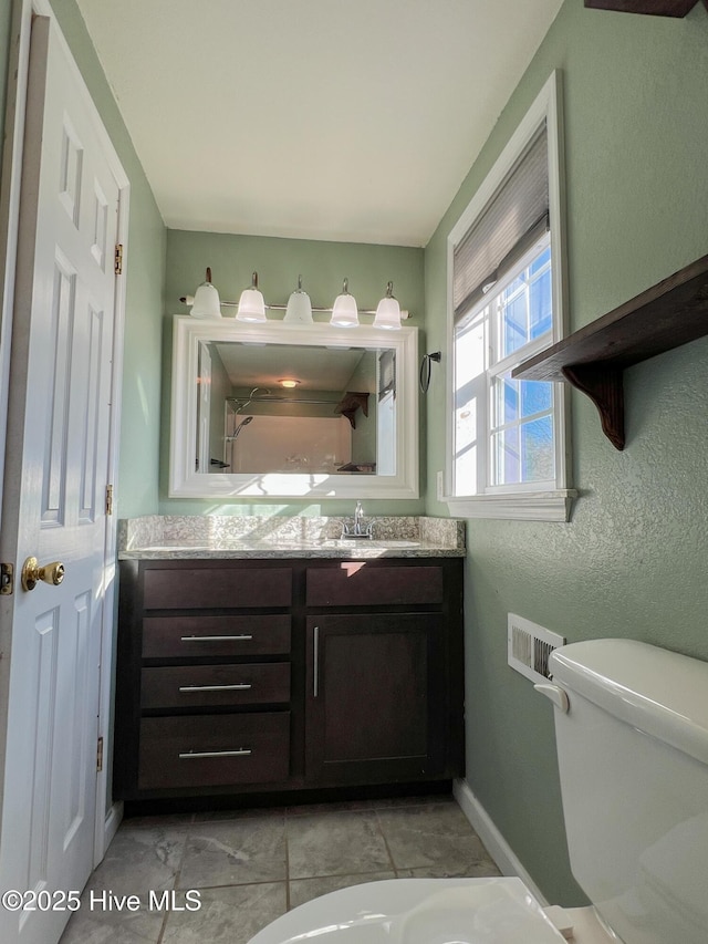 bathroom featuring tile patterned floors, vanity, and toilet