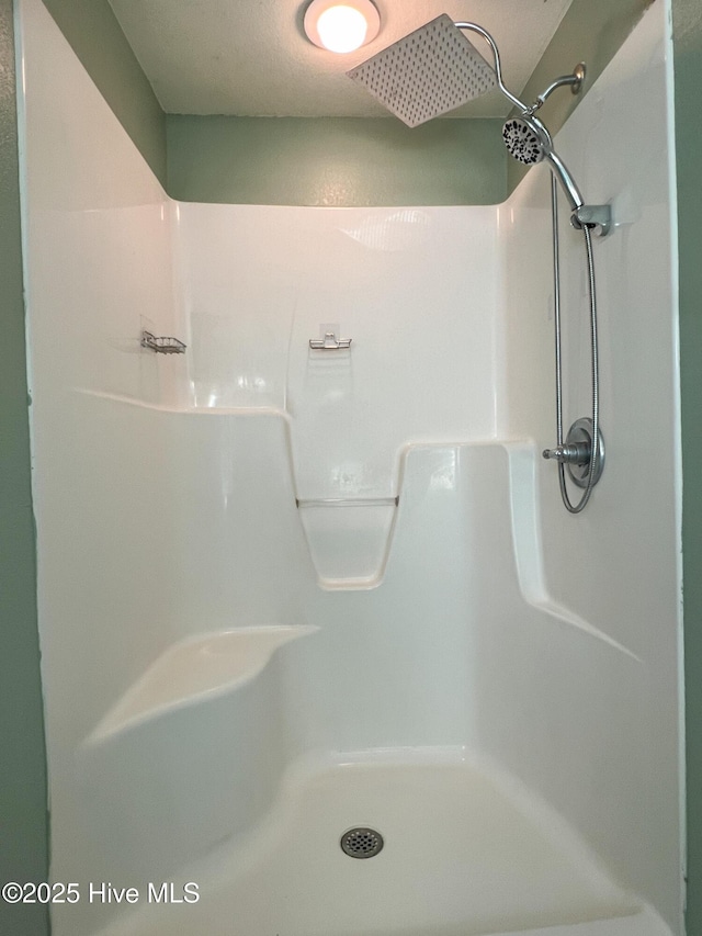 bathroom with a textured ceiling and walk in shower