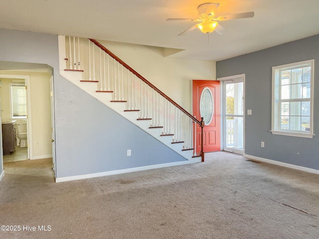 carpeted foyer with ceiling fan