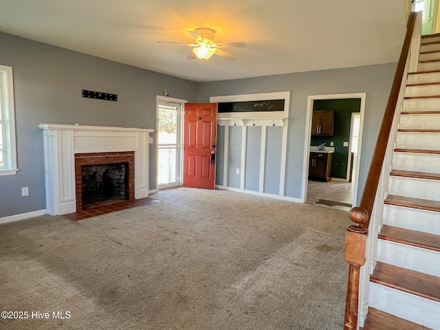 unfurnished living room with carpet, a brick fireplace, and ceiling fan