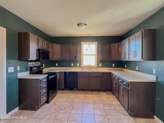 kitchen featuring sink, decorative light fixtures, dark brown cabinetry, and black appliances