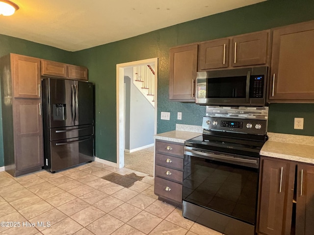 kitchen with appliances with stainless steel finishes and light tile patterned flooring