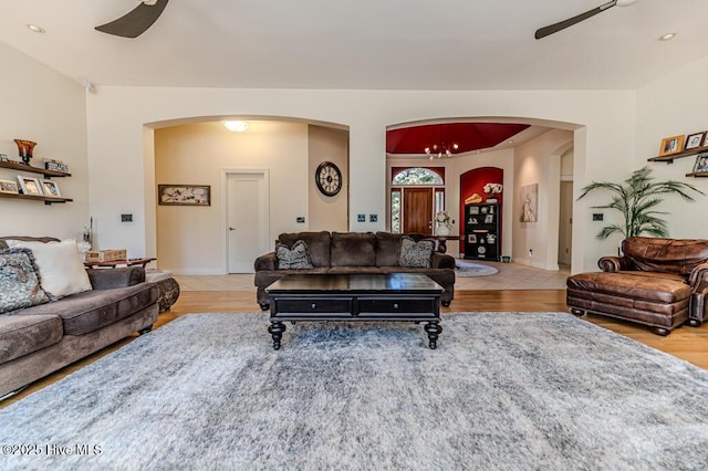 living room with ceiling fan with notable chandelier and light wood-type flooring